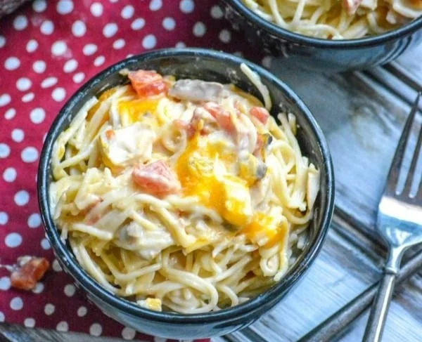 Cheesy Mexican Chicken Spaghetti topped with melted cheese and colorful peppers