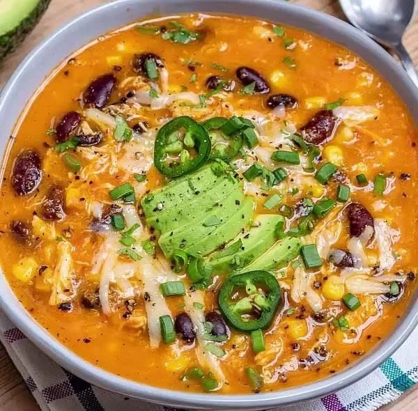 Delicious Chicken Enchilada Soup topped with cheese and cilantro in a bowl.