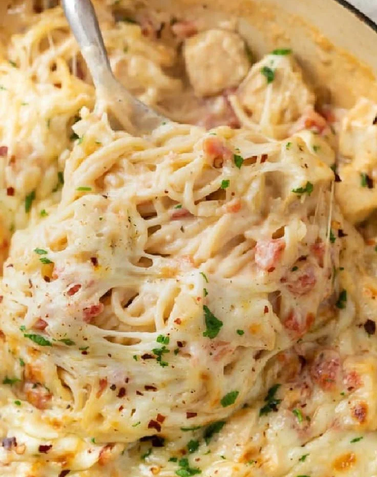 Delicious chicken spaghetti casserole topped with cheese and herbs