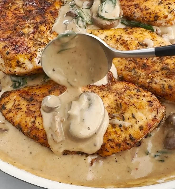 Creamy mushroom chicken dish garnished with fresh herbs