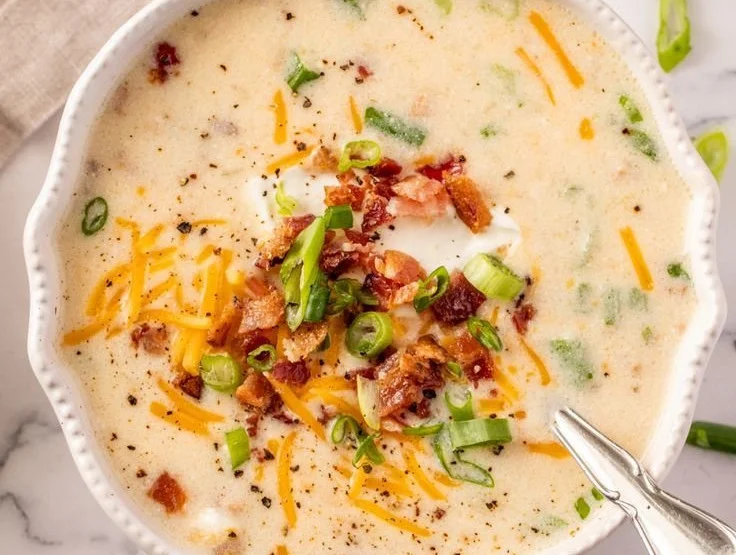 Delicious Crockpot potato soup served in a bowl with fresh herbs on top.