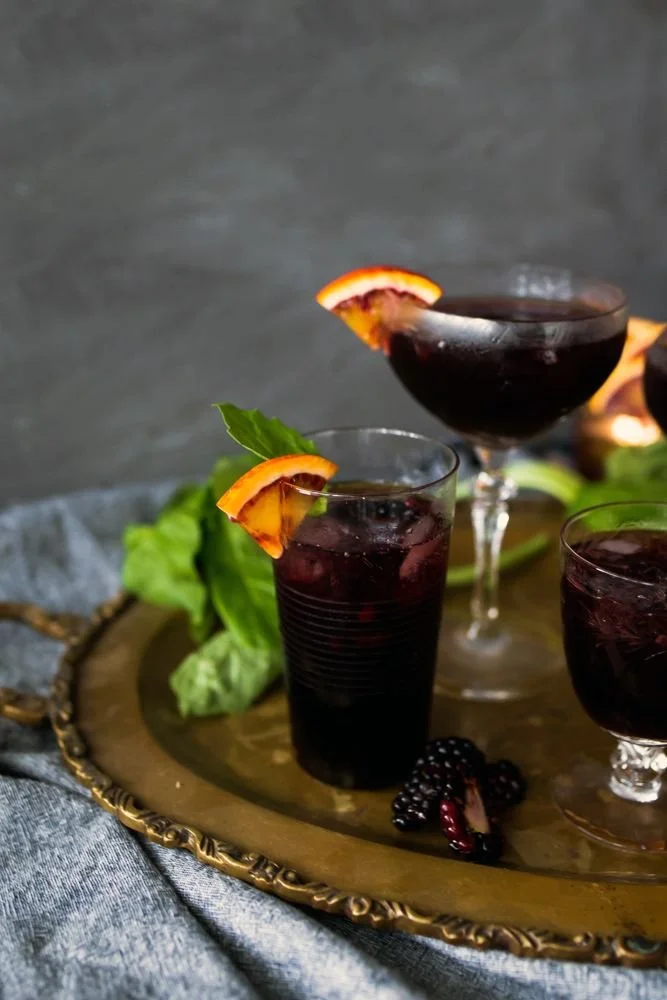 A dark magic punch cocktail, showcasing its mysterious deep color and garnishes.