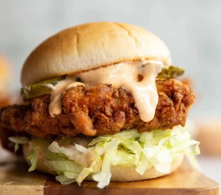 Delicious fried chicken sandwich with crispy chicken, lettuce, and sauce