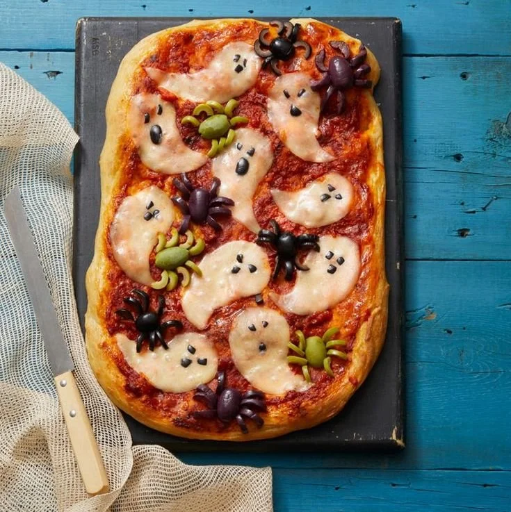 A spooky ghost-shaped pizza with eerie toppings, perfect for Halloween.