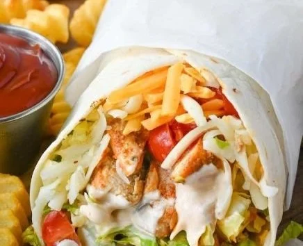 Delicious grilled chicken wrap filled with fresh vegetables and savory sauces.