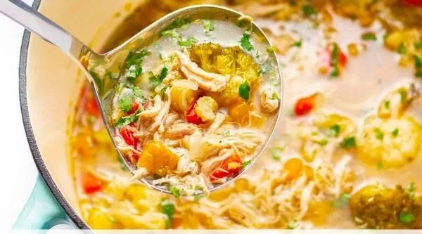 A bowl of healthy detox soup filled with colorful vegetables and herbs for cleansing