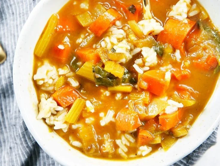 Bowl of immune-boosting soup with fresh vegetables and herbs