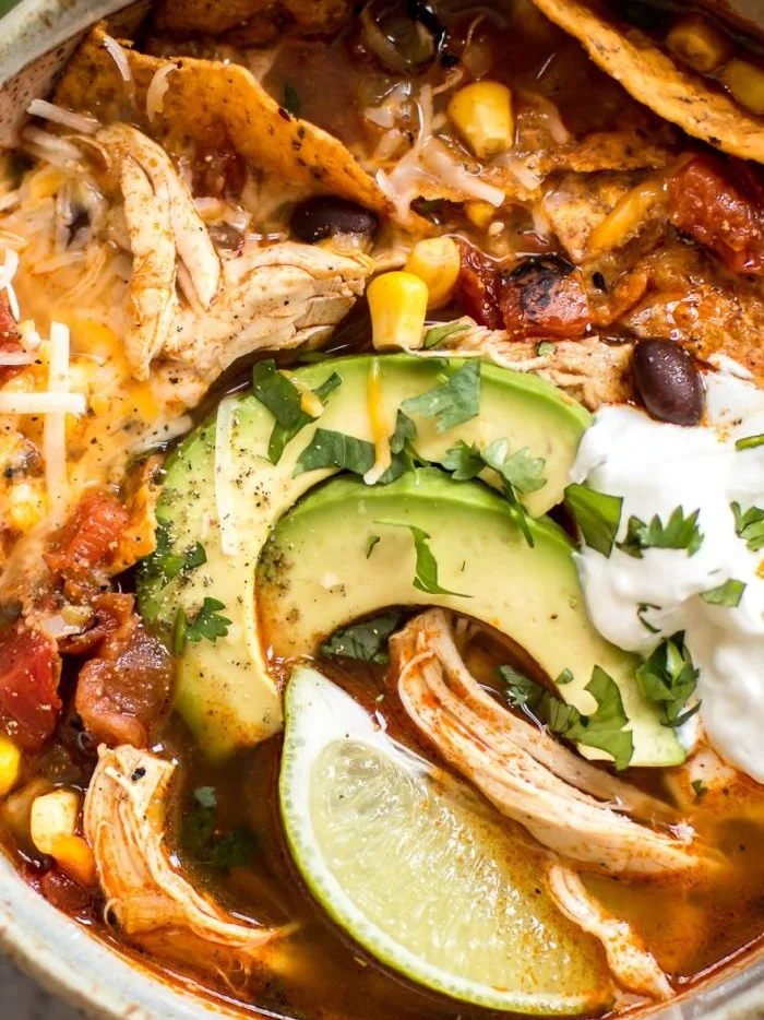 Bowl of delicious Instant Pot chicken tortilla soup garnished with tortilla strips and cilantro