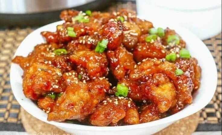 Instant Pot General Tso's Chicken served in a bowl with vegetables and rice