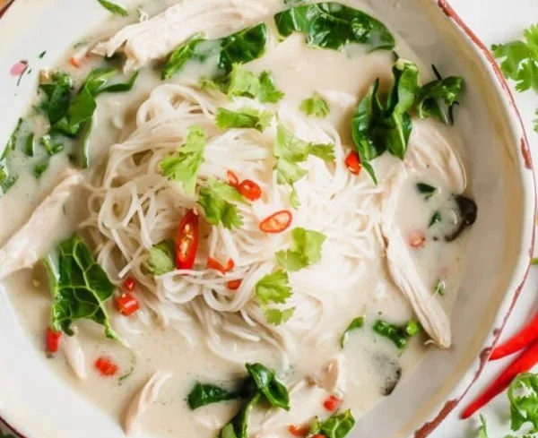 Bowl of Instant Pot Thai Coconut Lime Chicken Soup with Noodles garnished with lime