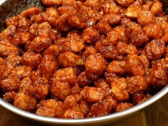 Crispy Korean popcorn chicken served with dipping sauce on a plate.
