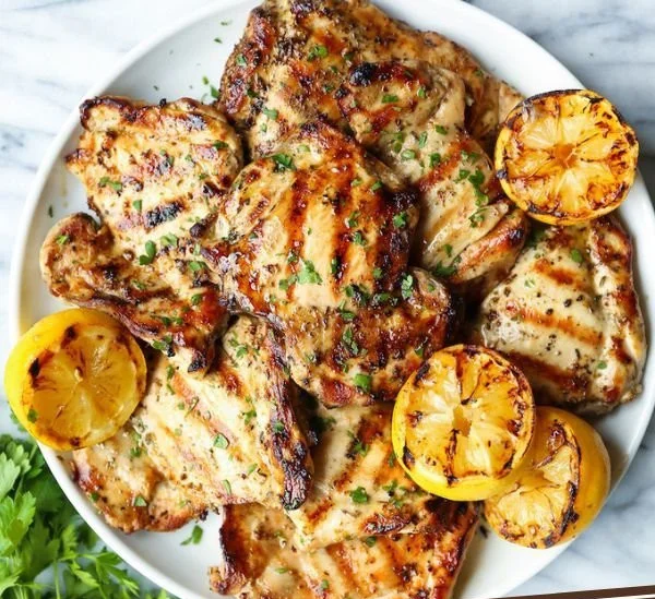 Lemon garlic chicken thighs garnished with herbs on a plate