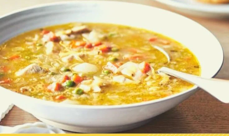Bowl of Ina Garten's chicken pot pie soup served with fresh herbs