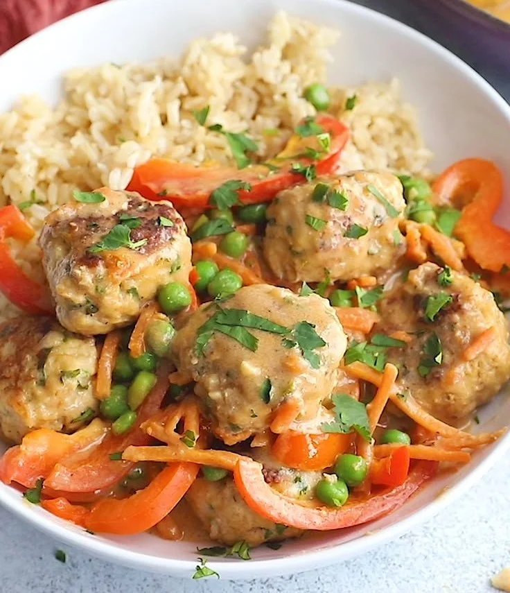 Delicious One Pan Ginger Chicken Meatballs served on a plate with herbs.
