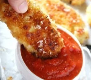 Parmesan crusted chicken tenders garnished with herbs on a plate
