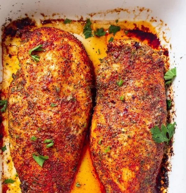 Juicy and tender perfect oven baked chicken breast garnished with herbs