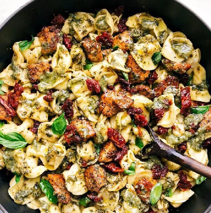 Plate of Pesto Chicken Tortellini garnished with fresh basil.