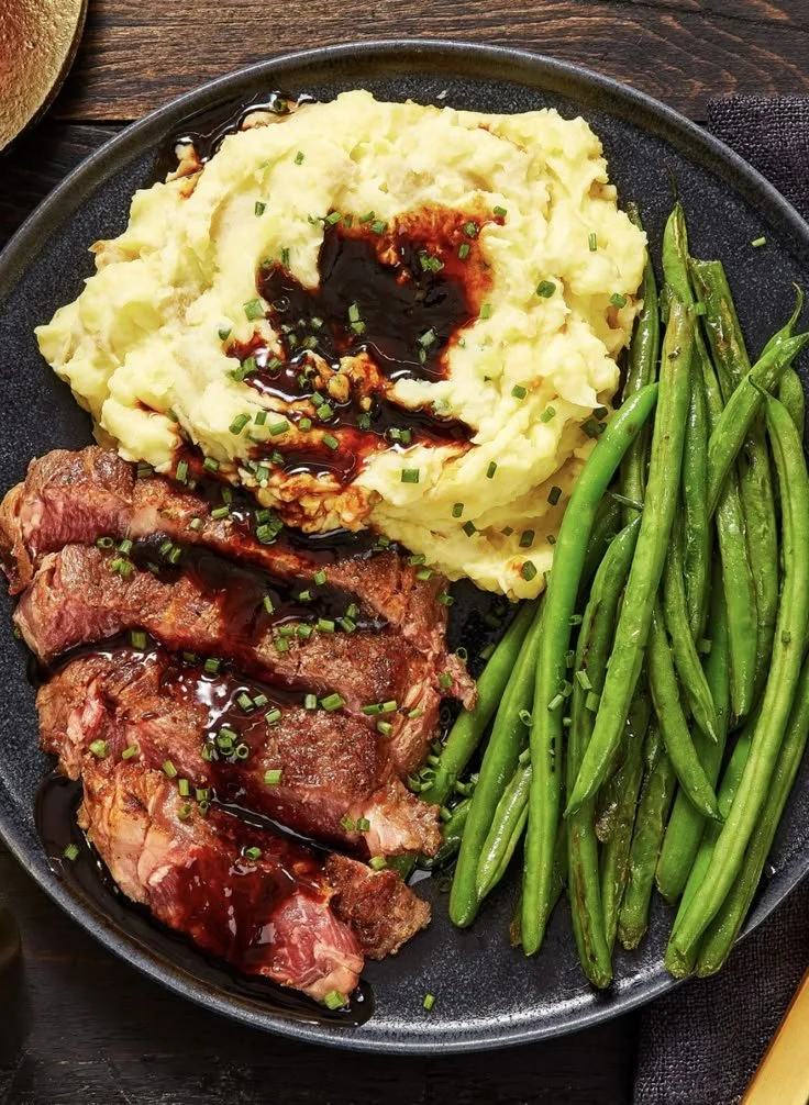 Ribeye steak with roasted garlic pan sauce on a plate.