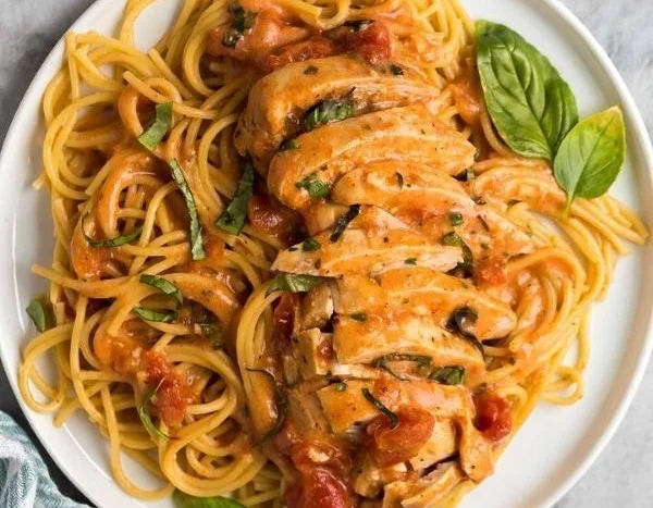 Slow cooker creamy tomato basil chicken served with fresh herbs