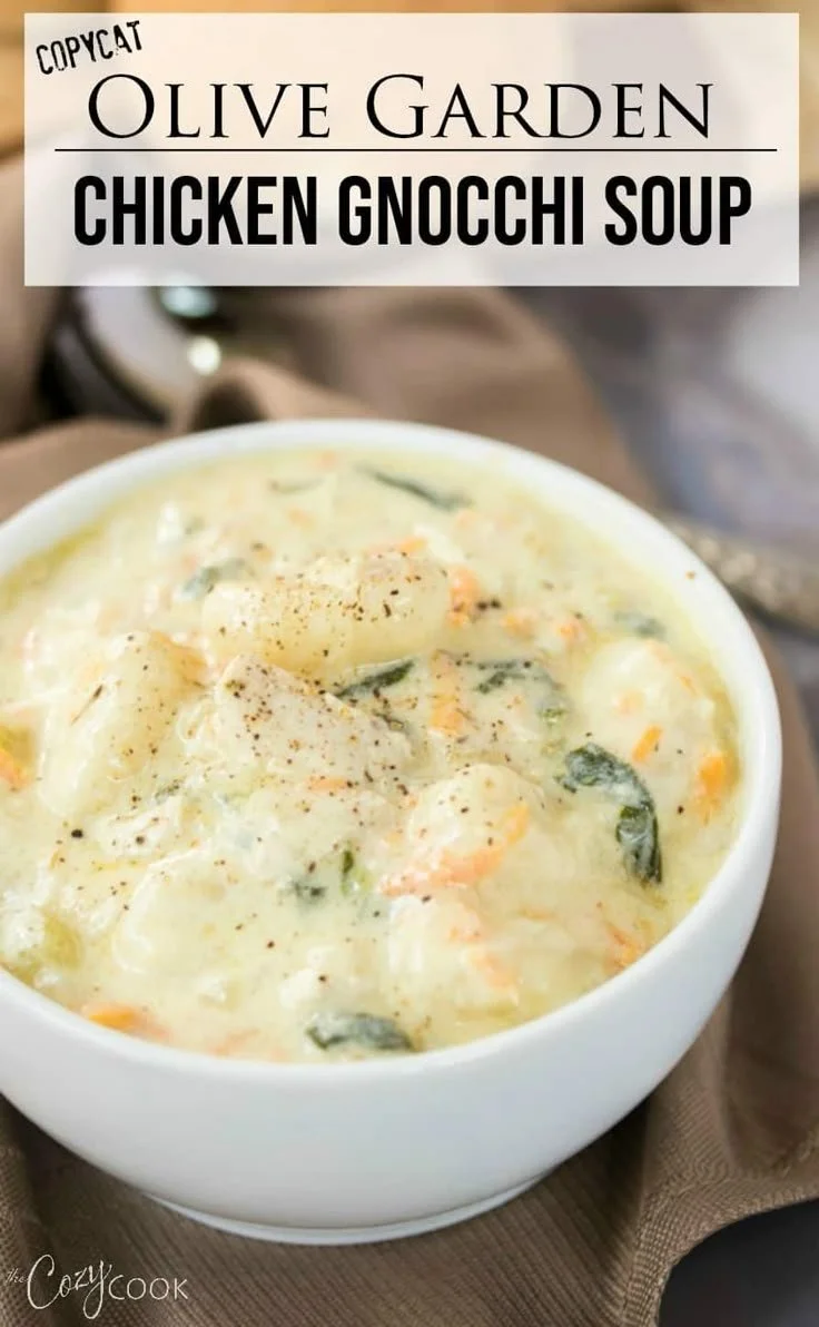 A bowl of creamy chicken gnocchi soup garnished with herbs.