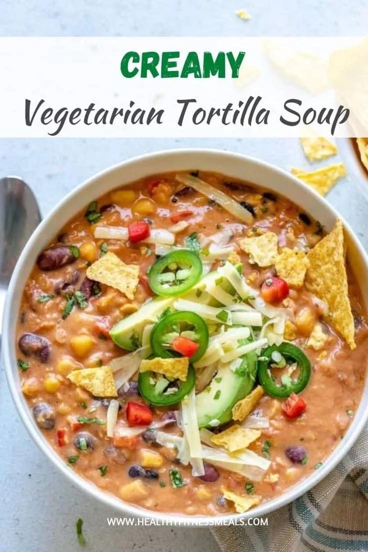 Creamy vegetarian tortilla soup in a bowl, garnished with avocado and tortilla strips