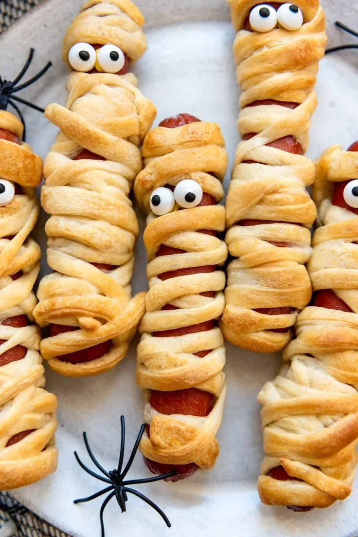 Easy Halloween mummy dogs wrapped in crescent roll dough and baked.