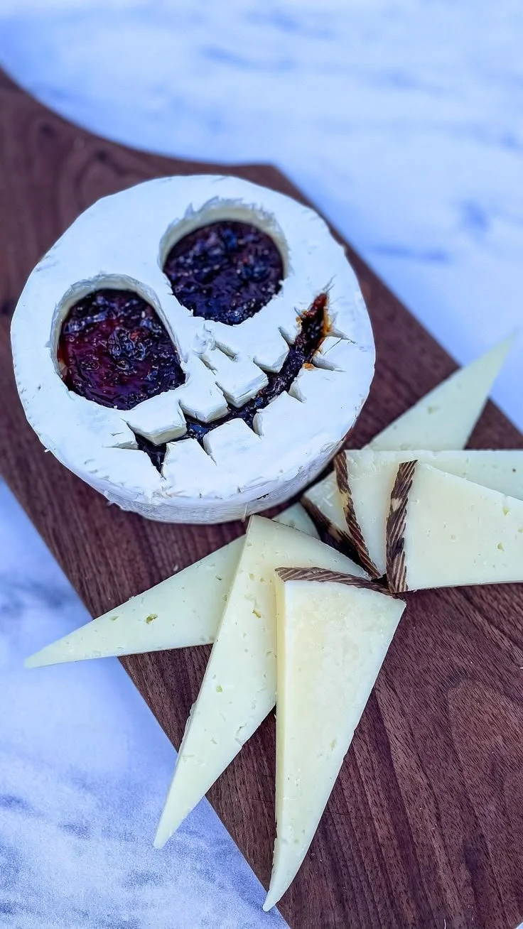 Halloween charcuterie board featuring Jack Skellington-themed cheese and treats.