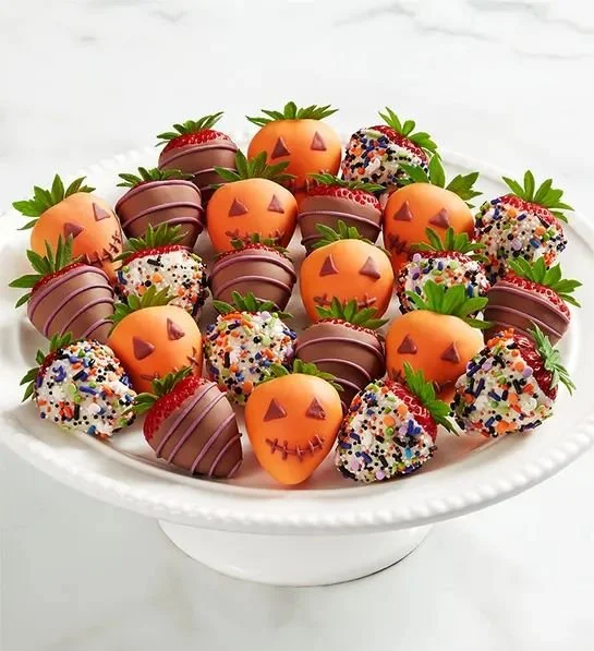 A spooky Halloween dip served with healthy snacks and Halloween-themed strawberries.