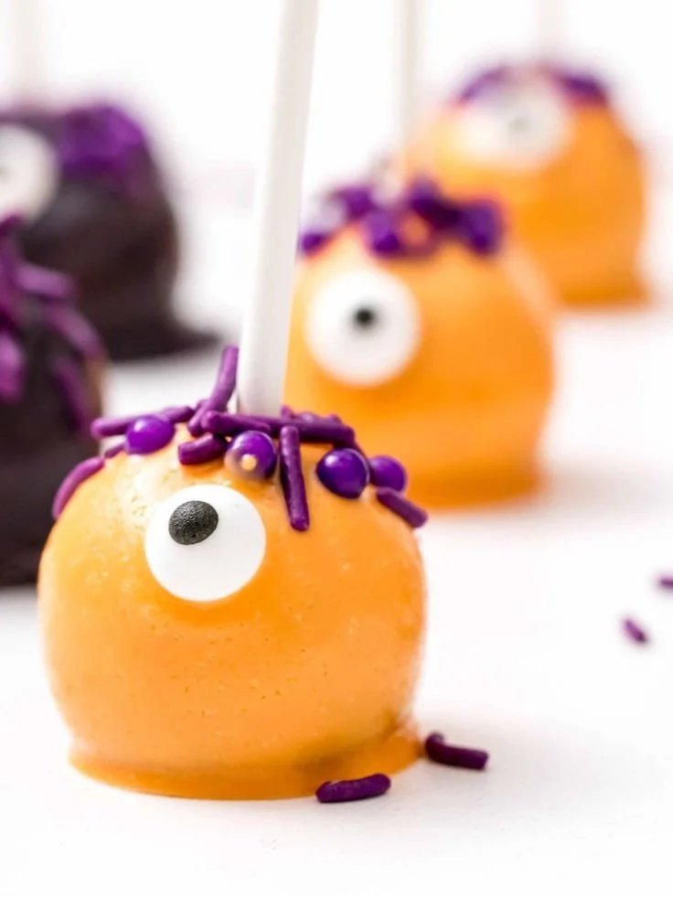 Halloween food ideas featuring monster cake pops and jack o' lantern peppers