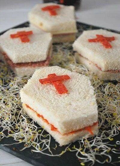 Spooky Halloween sandwiches decorated with red crosses and ghost themes.