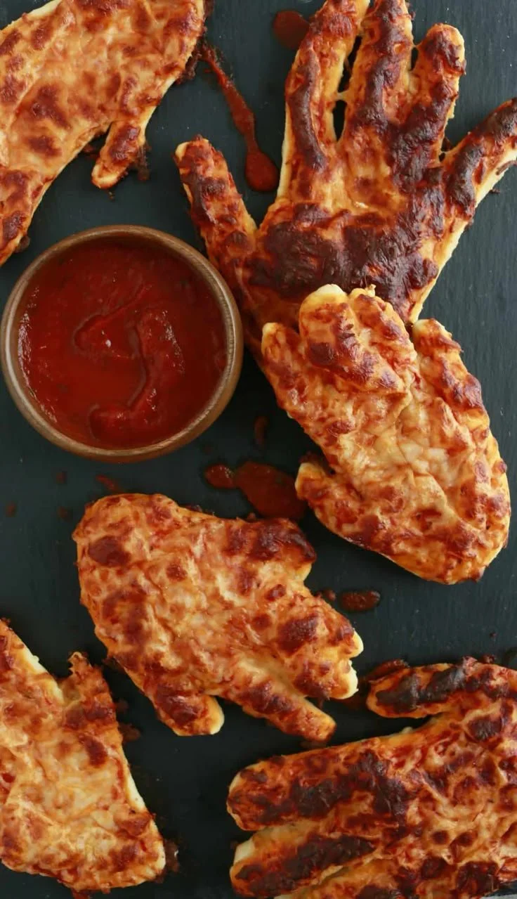 Creepy Halloween pizza hand appetizer for kids' party.