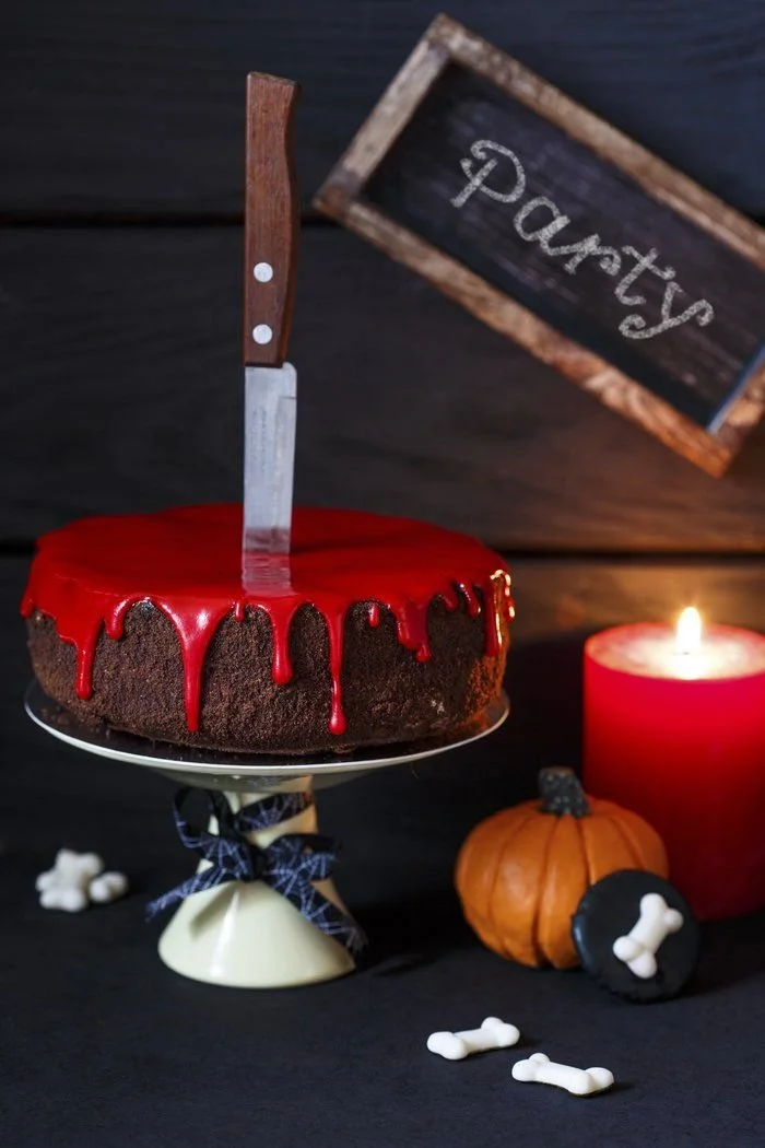 No Bake Vanille-Cheesecake with strawberry sauce and Halloween knife decoration
