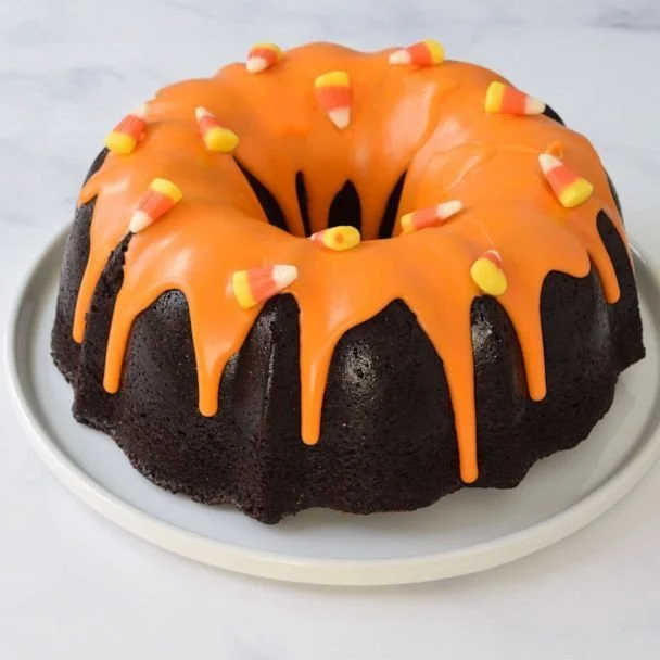 Halloween chocolate bundt cake with candy corn glaze on a dessert table
