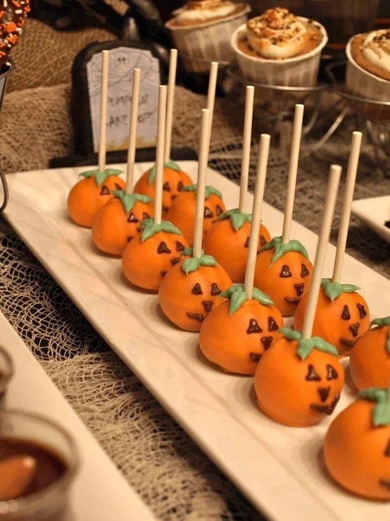 Colorful Halloween dessert table with spooky treats and decorations